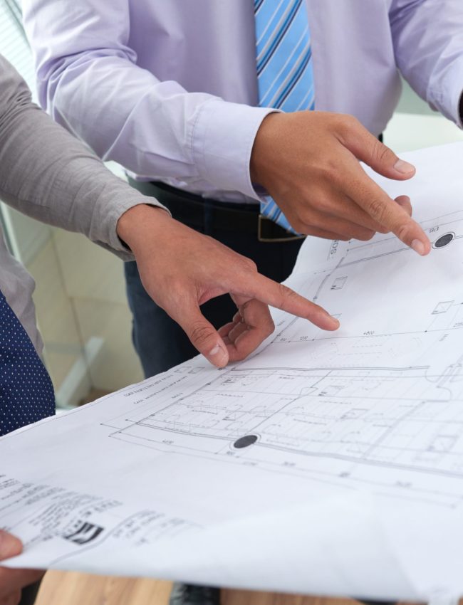 Close-up image of architects discussing blueprint of new building